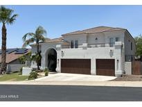 Stunning two-story home featuring a balcony and a spacious two-car garage with wood doors at 1318 E Villa Theresa Dr, Phoenix, AZ 85022