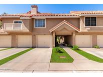 Inviting townhouse exterior with a well-maintained facade, garage, and charming landscaping at 1633 E Lakeside Dr # 25, Gilbert, AZ 85234