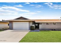 Charming single-story home with a well-maintained lawn, attached garage, and inviting walkway at 18410 N 104Th Ave, Sun City, AZ 85373