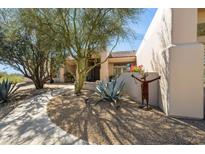 Inviting front exterior with stone landscaping, walkway, and artistic yard decor at 23520 N 80Th Way, Scottsdale, AZ 85255