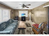 Cozy living room with wood paneling, a fireplace, and comfortable seating for a relaxed atmosphere at 25 S 102Nd St # 47, Mesa, AZ 85208