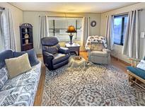 Comfortable living room featuring a plush sofa, recliner seating, patterned rug, and ample natural light at 25 S 102Nd St # 73, Mesa, AZ 85208