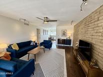 Inviting living room with stylish furnishings, brick accent wall, and wood-look flooring at 3737 E Turney Ave # 223, Phoenix, AZ 85018