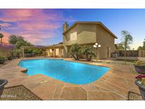 Stunning backyard pool with flagstone surround, lush landscaping, and covered patio is perfect for relaxing and entertaining at 609 W Mcnair St, Chandler, AZ 85225