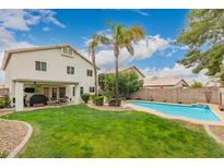 Expansive backyard with a refreshing pool, lush lawn, and outdoor dining area at 15809 N 11Th Ave, Phoenix, AZ 85023