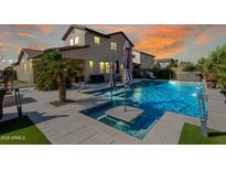 Backyard pool with umbrellas and hot tub at twilight for a relaxing oasis and outdoor entertaining at 18101 N Crestview Ln, Maricopa, AZ 85138