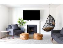 Bright living room features fireplace, mounted television, and hanging chair at 3907 E Marilyn Rd, Phoenix, AZ 85032