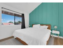 Bright bedroom featuring a statement wall, large window, and hardwood floors for a serene and inviting retreat at 413 E Linda Ln # D, Gilbert, AZ 85234