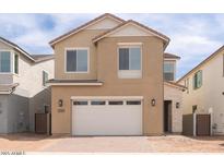 Two-story home featuring a two-car garage, tan stucco, and manicured landscaping at 1565 E Tiffany Way, Gilbert, AZ 85298