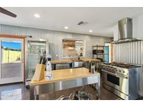 Contemporary kitchen features stainless steel appliances, an island, and a large window over looking the backyard at 2511 E Pinchot Ave, Phoenix, AZ 85016