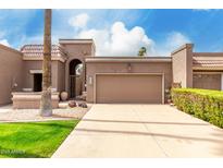 Charming home with a gated entry, brown garage door, desert landscaping, and a beautiful blue sky at 25238 S Mohawk Dr, Sun Lakes, AZ 85248