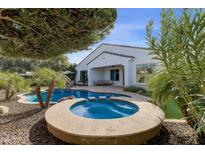 Backyard pool and hot tub with a tanning ledge, landscaping, and a covered patio for outdoor entertaining at 2896 E Maplewood St, Gilbert, AZ 85297