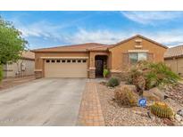 Charming single-story home with desert landscaping, two-car garage and security system at 37161 W Giallo Ln, Maricopa, AZ 85138