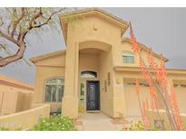 Charming two-story home with stucco exterior, desert landscaping, and covered front porch entry at 6778 W Lariat Ln, Peoria, AZ 85383