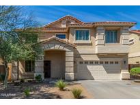 Charming two-story home featuring a stone-accented entry, a two-car garage, and a well-maintained front yard at 7622 S 69Th Dr, Laveen, AZ 85339