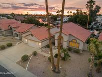 Beautiful desert home featuring a red tile roof, large driveway, and lush landscaping set against a scenic sunset backdrop at 186 N Starboard Dr, Gilbert, AZ 85234