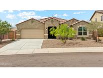 Charming single-story home featuring a well-manicured front yard and attached two-car garage at 31096 N 133Rd Ave, Peoria, AZ 85383