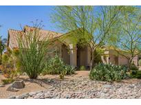 Inviting single-story home with well-manicured desert landscaping and covered entry at 12749 E Poinsettia Dr, Scottsdale, AZ 85259