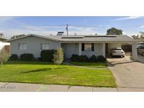 Charming single-story home featuring solar panels and a well-maintained lawn at 299 N Comanche Dr, Chandler, AZ 85224