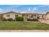 Charming single-story brick home featuring a covered carport and well-manicured front yard with mature landscaping at 299 N Comanche Dr, Chandler, AZ 85224