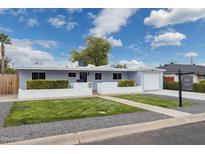 Charming single-story home features a manicured front yard and a lovely, light blue painted facade at 4907 E Piccadilly Rd, Phoenix, AZ 85018