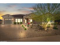 Charming home featuring desert landscaping, a stone facade, and a brick driveway at sunset at 10778 N 137Th St, Scottsdale, AZ 85259