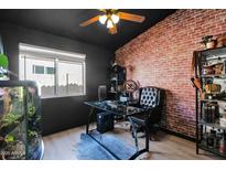 Office featuring a brick accent wall, glass desk and large window at 30430 N 42Nd Pl, Cave Creek, AZ 85331