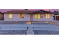 Charming single-story home showcasing a well-maintained front yard and exterior lighting at 3209 E Marilyn Rd, Phoenix, AZ 85032
