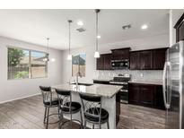 Modern kitchen with granite counters, stainless steel appliances, dark cabinetry, and an island with seating at 4253 E Palo Verde St, Gilbert, AZ 85296