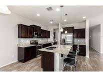 Contemporary kitchen boasting granite countertops, stainless steel appliances, dark cabinets, and an eat-in island at 4253 E Palo Verde St, Gilbert, AZ 85296