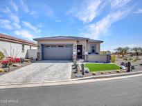 Charming single-story home featuring a paver driveway, stone accents, and desert landscaping at 5581 N 206Th Ave, Buckeye, AZ 85396