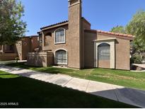 Charming condo exterior with a red tile roof, stucco walls, and a well-maintained lawn at 6945 E Cochise Rd # 108, Paradise Valley, AZ 85253