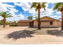 Cozy home with a two-car garage, complemented by mature palm trees and easy-to-maintain gravel landscaping at 8637 E Weldon Ave, Scottsdale, AZ 85251