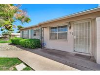 Charming single-story home featuring manicured landscaping, security door, and beautiful mature shade tree at 903 N Revere St # F, Mesa, AZ 85201