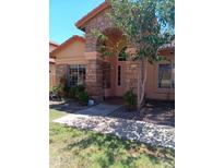 Charming single story home with an arched stone entryway and well maintained front yard at 11233 W Olive Dr, Avondale, AZ 85392