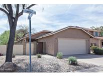 Charming single-story home with a two-car garage, desert landscaping, and a welcoming facade at 5013 E Shomi St, Phoenix, AZ 85044