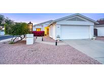 Charming single-story home with two-car garage, xeriscape landscape, and inviting entryway with mature landscaping at 614 W Kings Ave, Phoenix, AZ 85023