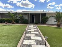 Charming home featuring a lovely landscaped front yard and inviting walkway at 6207 W Orange Dr, Glendale, AZ 85301