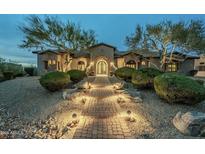 Inviting custom home featuring a brick walkway, lush greenery, and unique architectural design at 7260 E Eagle Crest Dr # 13, Mesa, AZ 85207