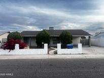 Charming single-story home with a well-maintained front yard and a white brick fence for added curb appeal at 8719 W Monterey Way, Phoenix, AZ 85037
