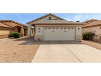 Beige single-story home featuring a two-car garage and low-maintenance gravel landscaping at 9733 W Purdue Ave, Peoria, AZ 85345