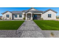 Beautiful single-story home with manicured lawn, gray stone pathway, and stylish exterior accents at 1244 N 106Th Pl, Mesa, AZ 85207