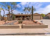 Charming single-story home featuring desert landscaping, a two-car garage, and a covered front porch at 1403 W Wood Dr, Phoenix, AZ 85029
