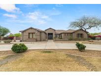 Charming home featuring a well-manicured front yard, a long private driveway, and desert landscaping at 14539 W Becker Ln, Surprise, AZ 85379