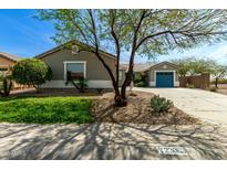 Charming single-story home with a well-manicured front yard and vibrant desert landscaping under a clear blue sky at 23063 W Loma Linda Blvd, Buckeye, AZ 85326