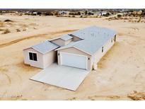 New home with a modern design, neutral colors, a two-car garage, and a concrete driveway at 25745 W Peak View Rd, Wittmann, AZ 85361