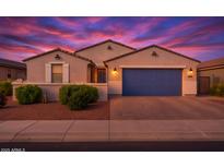Charming single-story home featuring a blue garage door, desert landscaping, and a colorful sunset backdrop at 4140 E Caitlin Dr, San Tan Valley, AZ 85140