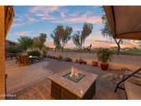 Relaxing patio with a fire pit, lounge chairs and serene views of the golf course and desert landscape at 6339 S Palo Blanco Dr, Gold Canyon, AZ 85118