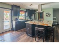 Modern kitchen with dark wood cabinets, stainless steel appliances, and granite countertops at 6428 E Shea Blvd, Scottsdale, AZ 85254