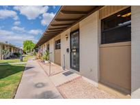 Charming front door with security screen, desert landscaping, and an American flag at 6721 E Mcdowell Rd # H324, Scottsdale, AZ 85257